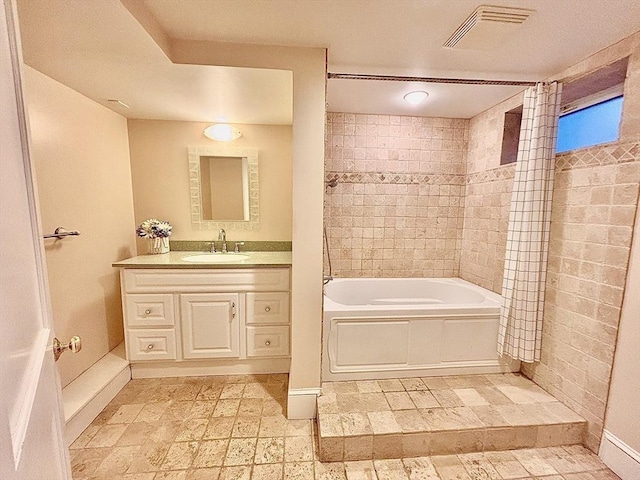 full bathroom featuring visible vents, vanity, baseboards, and bathing tub / shower combination