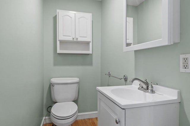 bathroom with toilet, hardwood / wood-style flooring, and vanity