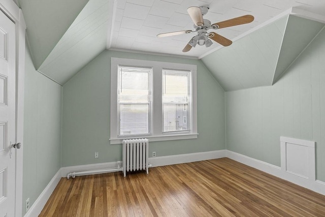 bonus room with ceiling fan, hardwood / wood-style floors, radiator heating unit, and vaulted ceiling