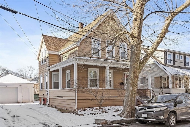 front facade with a garage and an outbuilding