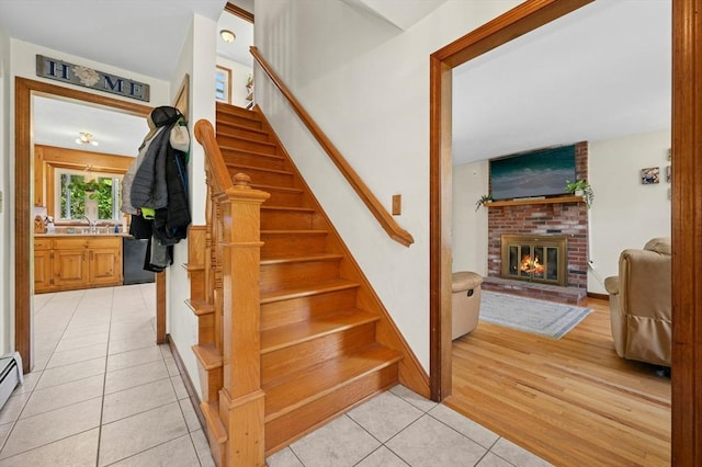 3 Bellingham Rd, Blackstone, MA 01504 - stairs with tile patterned flooring and a brick fireplace