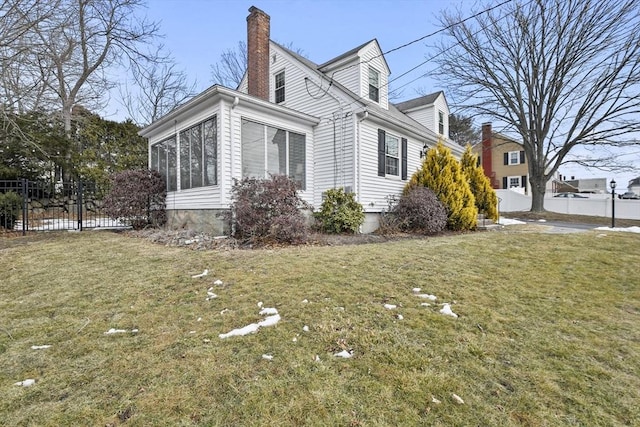 view of property exterior with a sunroom, a lawn, a chimney, and fence