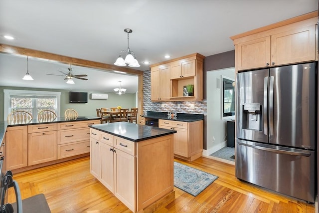 kitchen featuring stainless steel fridge, a center island, light hardwood / wood-style floors, and decorative light fixtures