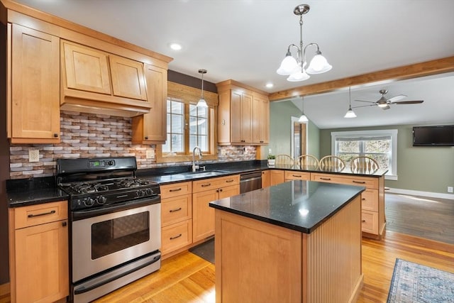 kitchen with pendant lighting, sink, tasteful backsplash, kitchen peninsula, and stainless steel appliances