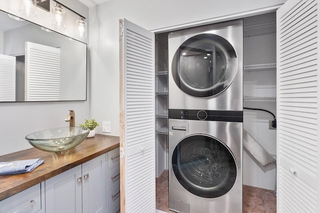 laundry room featuring sink and stacked washing maching and dryer