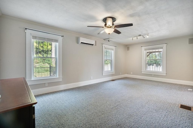 carpeted empty room with an AC wall unit, a wealth of natural light, ceiling fan, and ornamental molding