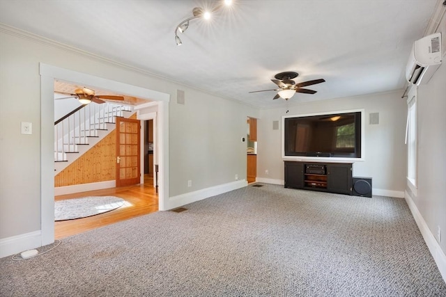 unfurnished living room with wood-type flooring, an AC wall unit, and crown molding