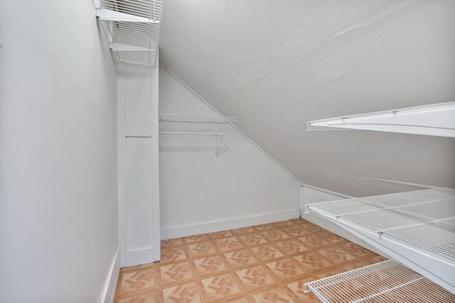 spacious closet featuring light parquet floors and lofted ceiling