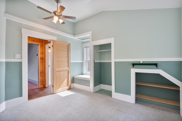 unfurnished bedroom with carpet flooring, ceiling fan, and vaulted ceiling