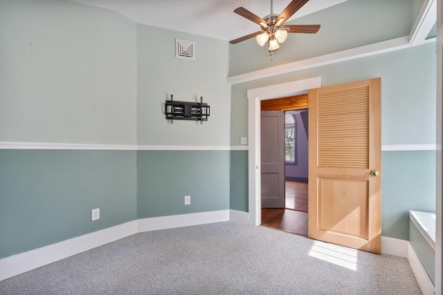 carpeted spare room featuring ceiling fan