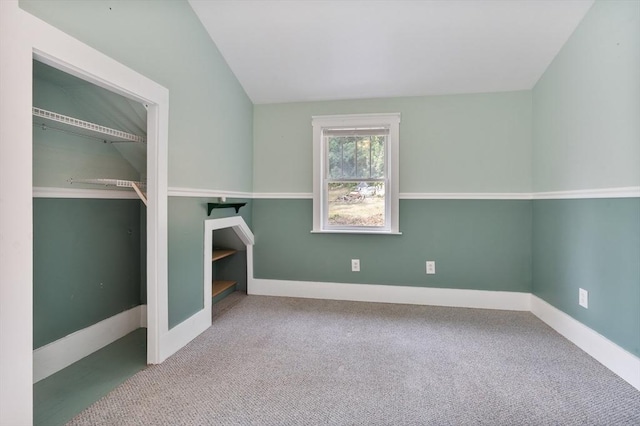 interior space featuring carpet floors and vaulted ceiling