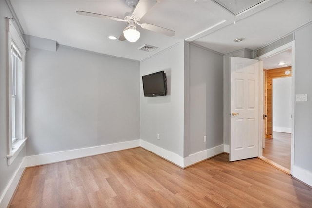 empty room with ceiling fan and light hardwood / wood-style flooring