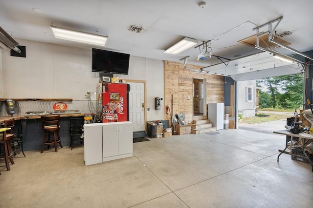 garage with a workshop area and a garage door opener