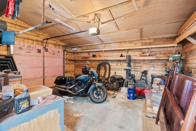 garage with a garage door opener and wooden walls