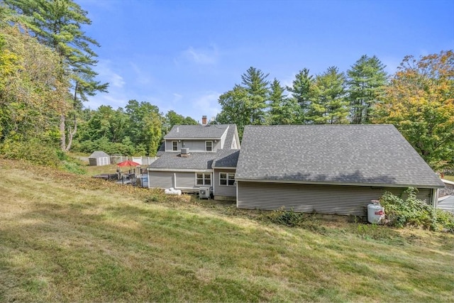 rear view of house with a yard and a shed