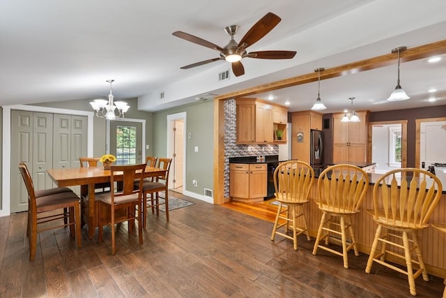 dining room featuring vaulted ceiling, ceiling fan with notable chandelier, and dark hardwood / wood-style floors