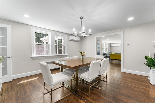 dining space featuring a chandelier, a wall mounted AC, baseboards, and wood finished floors