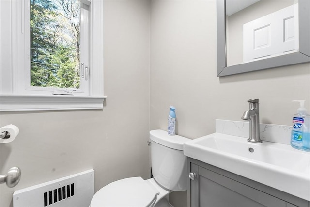 bathroom featuring toilet, vanity, and radiator heating unit