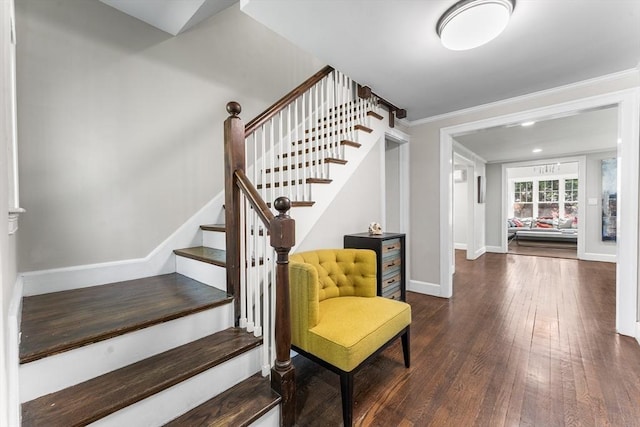 staircase with baseboards, crown molding, and wood finished floors