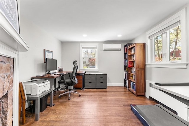 home office featuring a wall mounted air conditioner, wood finished floors, baseboards, and recessed lighting