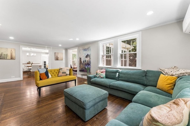 living area featuring ornamental molding, a notable chandelier, and wood finished floors