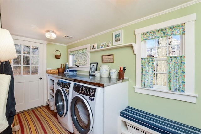 laundry area with crown molding, visible vents, radiator heating unit, washing machine and dryer, and laundry area