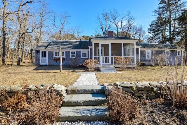 view of front of house with a sunroom and a chimney