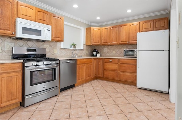 kitchen featuring sink, crown molding, tasteful backsplash, light tile patterned floors, and appliances with stainless steel finishes