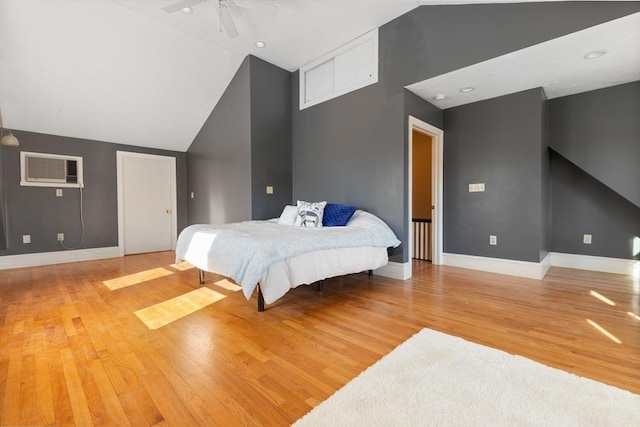 bedroom with ceiling fan, lofted ceiling, a wall mounted air conditioner, and hardwood / wood-style floors