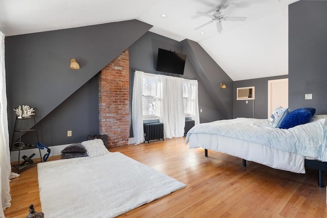 bedroom featuring lofted ceiling, light hardwood / wood-style flooring, radiator heating unit, a wall unit AC, and ceiling fan