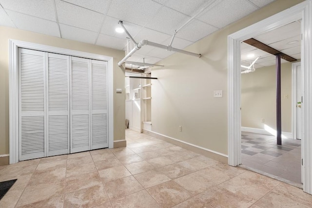 unfurnished bedroom with a drop ceiling and a closet