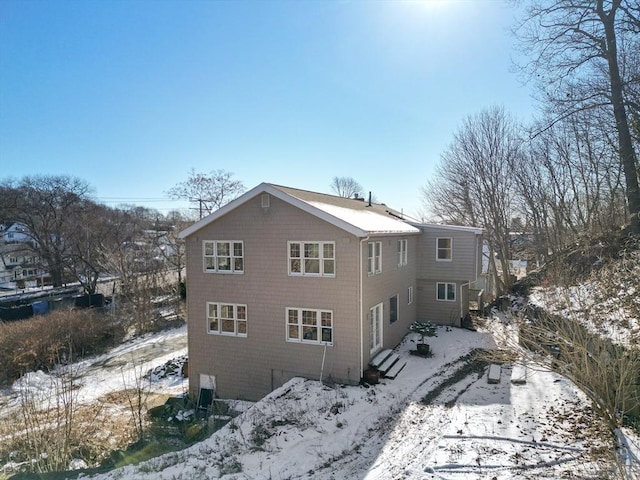 view of snow covered back of property