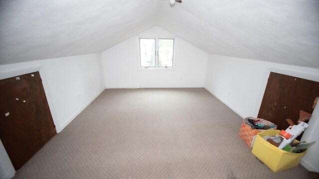 bonus room featuring vaulted ceiling, carpet flooring, and baseboards