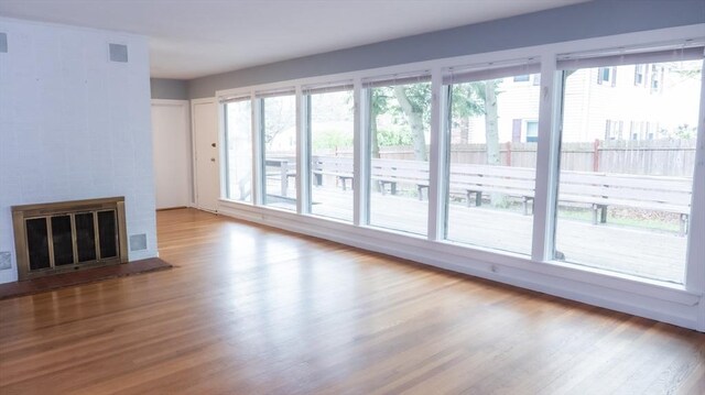 unfurnished living room featuring wood finished floors and a glass covered fireplace