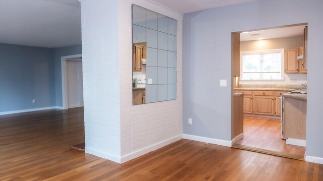 corridor with light wood-type flooring and baseboards