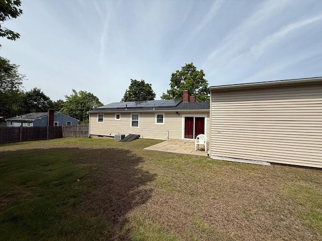16 Firglade Dr, Attleboro, MA 02703 - rear view of property featuring a patio, roof mounted solar panels, a chimney, and central AC