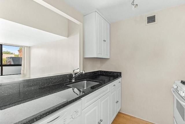 42 8th St Unit 1307, Boston, MA 02129 - kitchen with a sink, white appliances, dark stone countertops, white cabinetry, and light wood finished floors