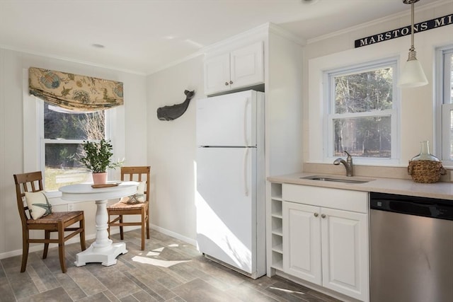 kitchen with dishwasher, a sink, freestanding refrigerator, and white cabinets