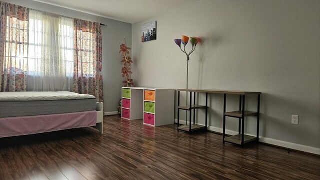 bedroom featuring baseboards and wood finished floors