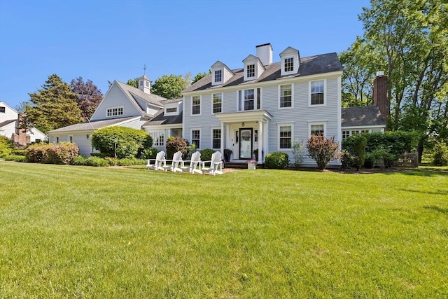 colonial house with a front yard and a chimney