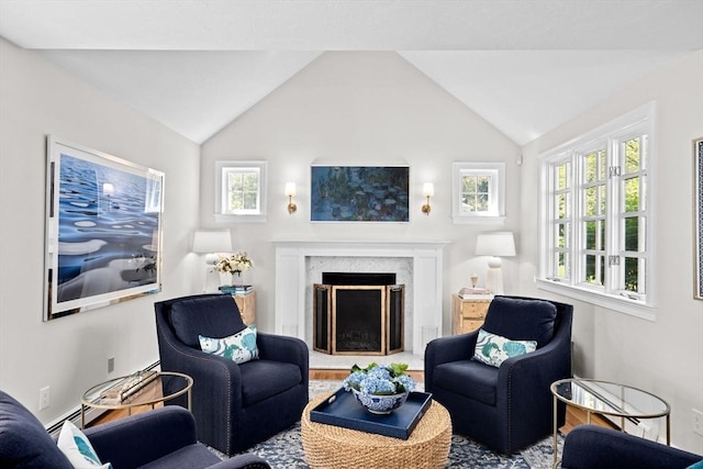 living area with a high end fireplace and vaulted ceiling
