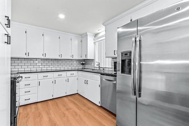 40 Chase Rd, Marlborough, MA 01752 - kitchen with stainless steel appliances, dark countertops, decorative backsplash, light wood-style flooring, and white cabinetry