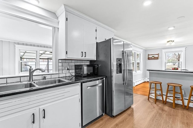 40 Chase Rd, Marlborough, MA 01752 - kitchen featuring appliances with stainless steel finishes, light wood-style floors, a baseboard heating unit, dark countertops, and white cabinets