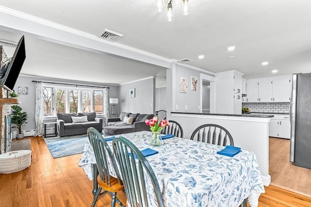 40 Chase Rd, Marlborough, MA 01752 - dining room with ornamental molding, light wood-style flooring, recessed lighting, and a fireplace with raised hearth