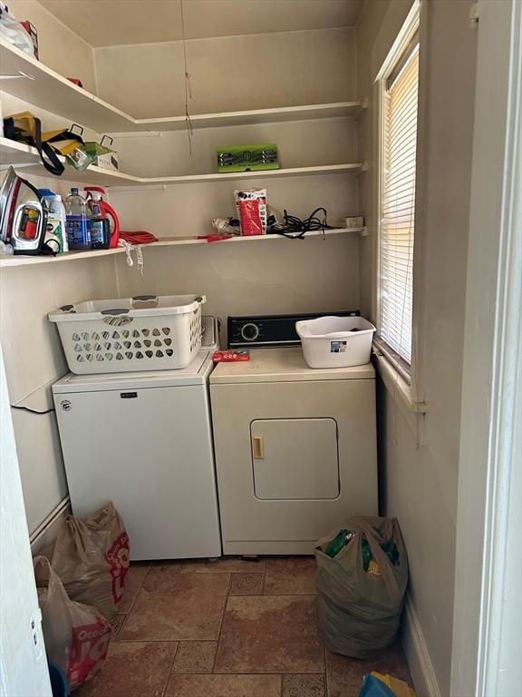 laundry room featuring a healthy amount of sunlight and washing machine and clothes dryer