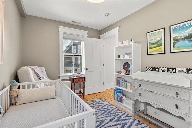 bedroom featuring light wood-style flooring and visible vents
