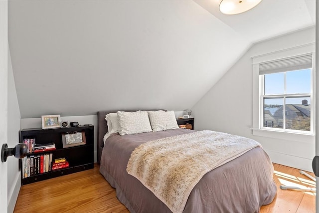 bedroom with lofted ceiling and light wood-type flooring
