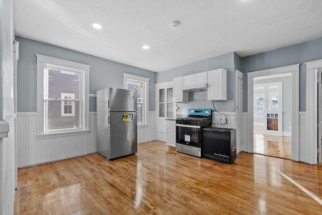 kitchen with white cabinetry, stainless steel appliances, and light hardwood / wood-style floors