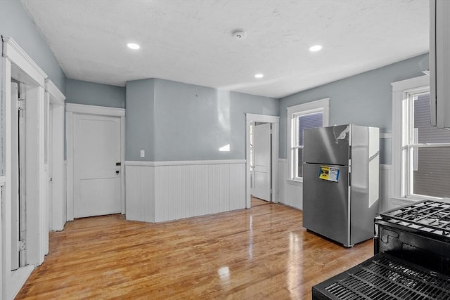 kitchen featuring stainless steel fridge and light hardwood / wood-style flooring