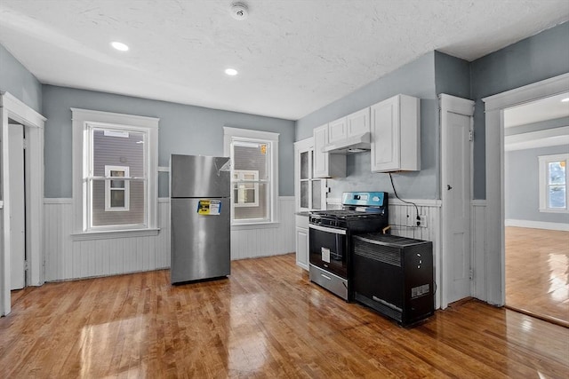 kitchen featuring light hardwood / wood-style floors, white cabinets, and appliances with stainless steel finishes